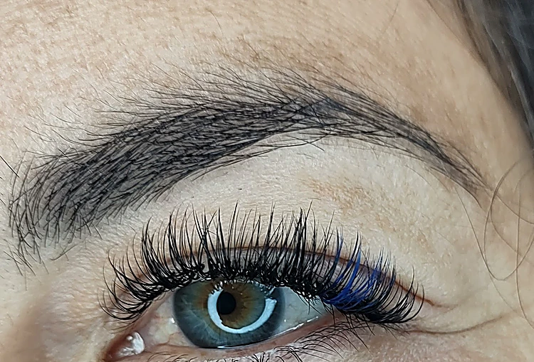 Primer plano de un ojo con pestañas largas y puntas azules