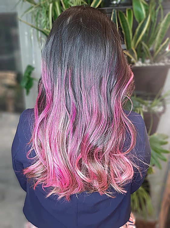 Degradado de castaño a rosa chicle en ondas, de espaldas, con plantas al fondo